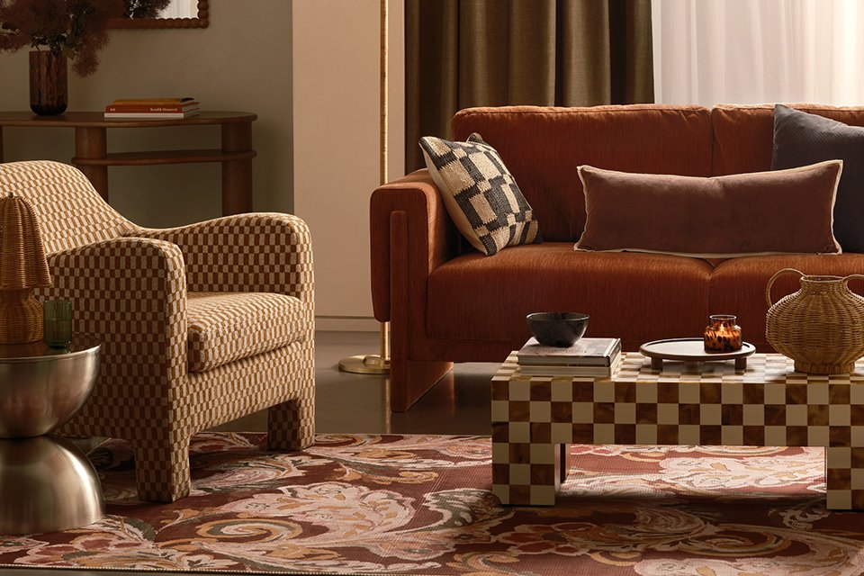 A living room with a patterned coffee table next to a sofa.