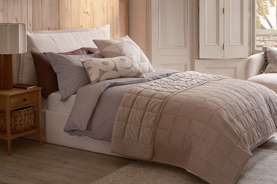A cosy bed with pillows in a bedroom.