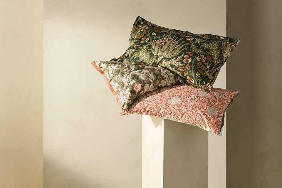 Morris and co habitat floral bedding and cushions on floral headboard.