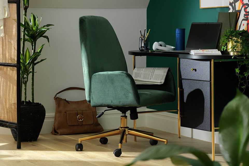Velvet green desk chair by blue and gold desk. 