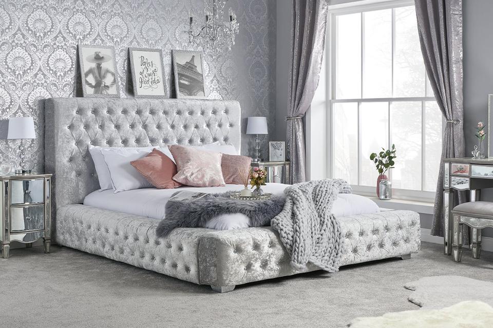 Grey velvet bed frame in bedroom.