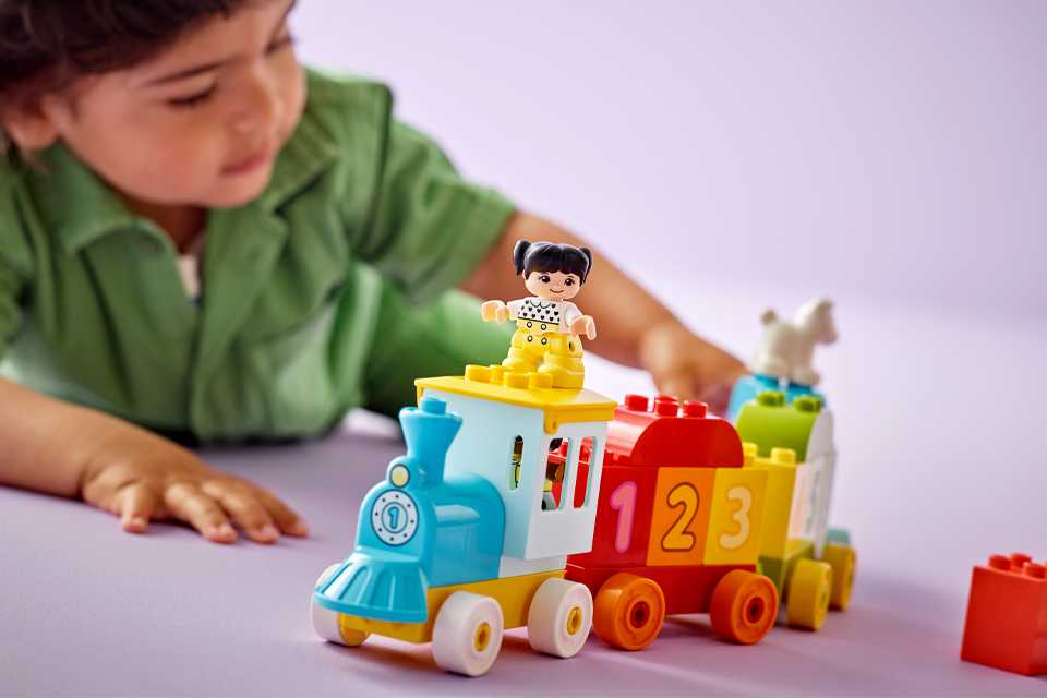 Close up shot of a baby playing with LEGO Duplo number train set.