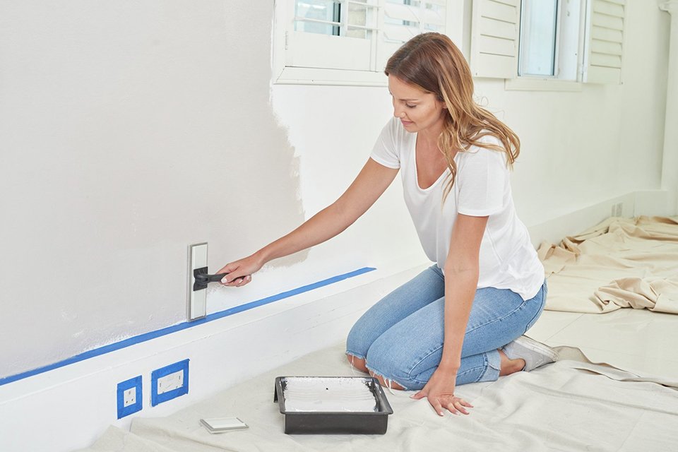 A woman painting a wall.