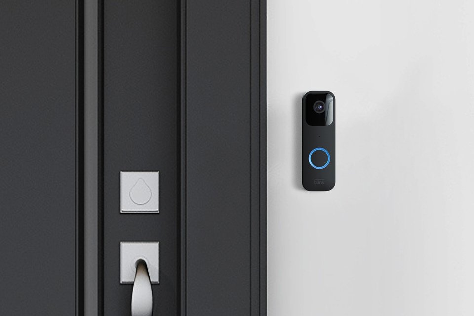 A black Blink video doorbell installed beside the main entrance door. 
