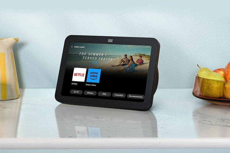 A black Amazon Echo Show 8 (3rd Gen) smart speaker placed on kitchen countertop with other things.