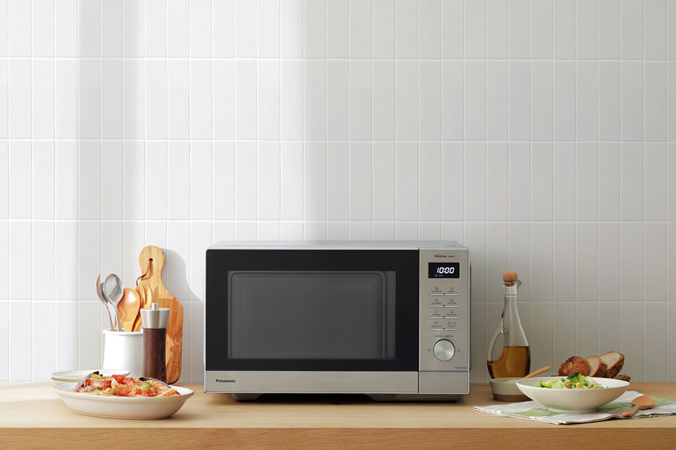 Panasonic 1000W Standard Microwave NN-SD37QSBPQ in grey colour placed on a wooden counter.