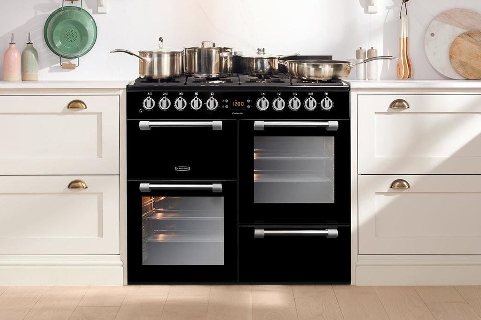Multiple pots on a range cooker in a kitchen.