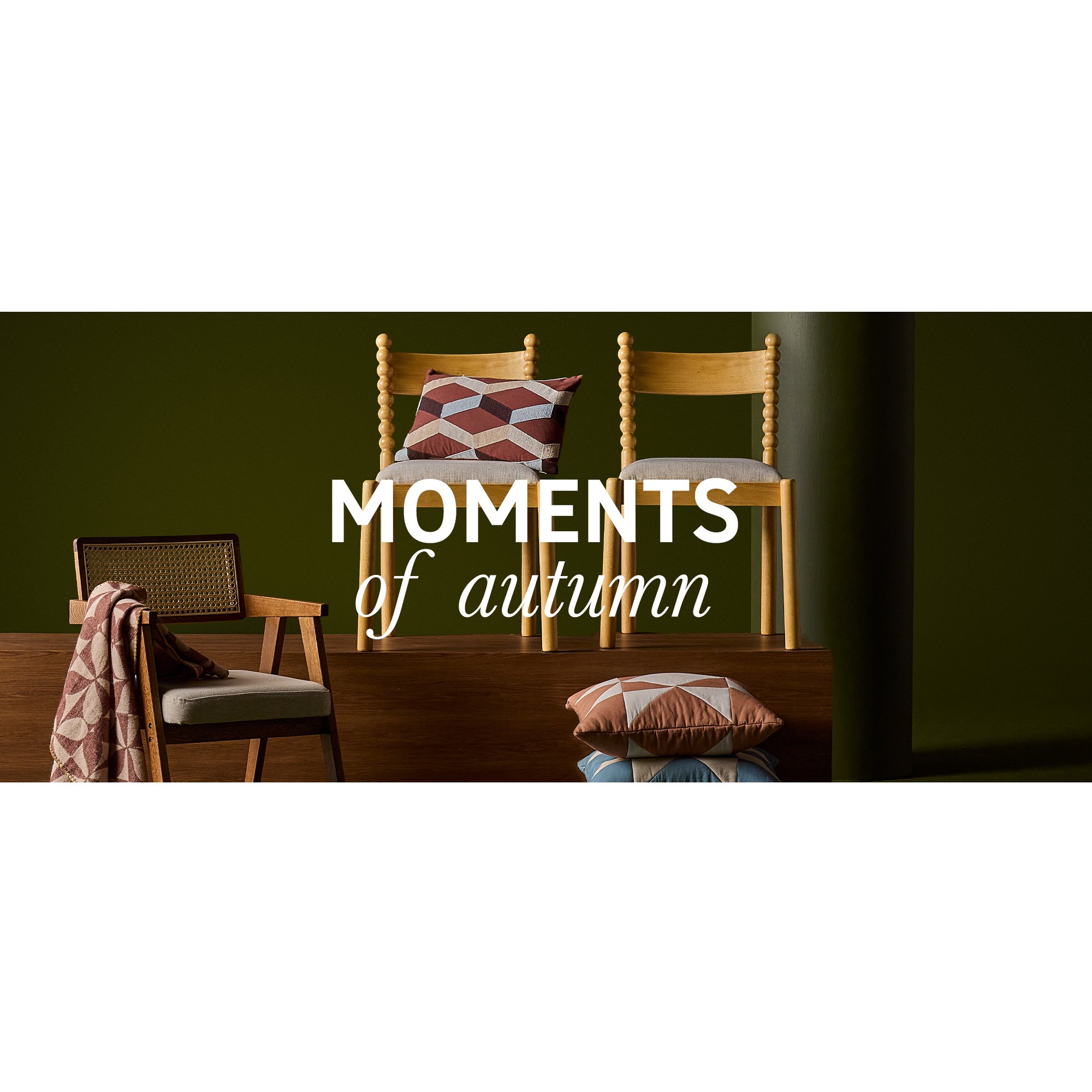 A banner displaying wooden chairs with a cosy throw and patterned cushions on and around them.