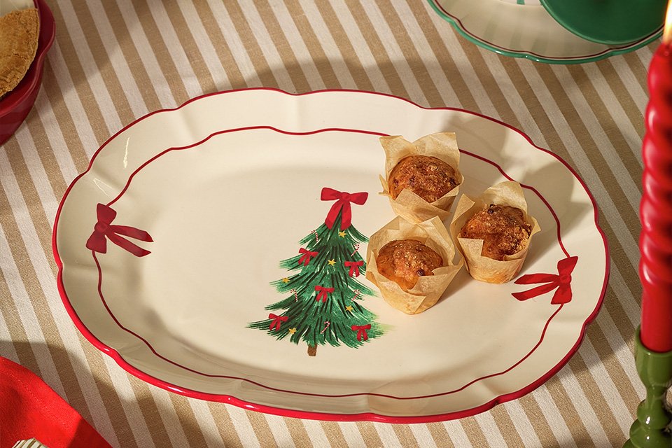 A serving plate with bows on the sides and a bow on a Christmas tress motif.
