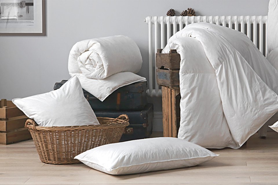 Two rolled up duvets and two pillows in a room.