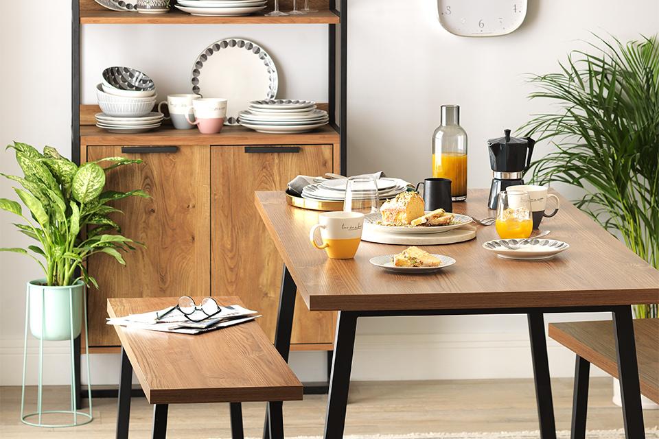 Modern wood and black metal table and two benches, set for breakfast