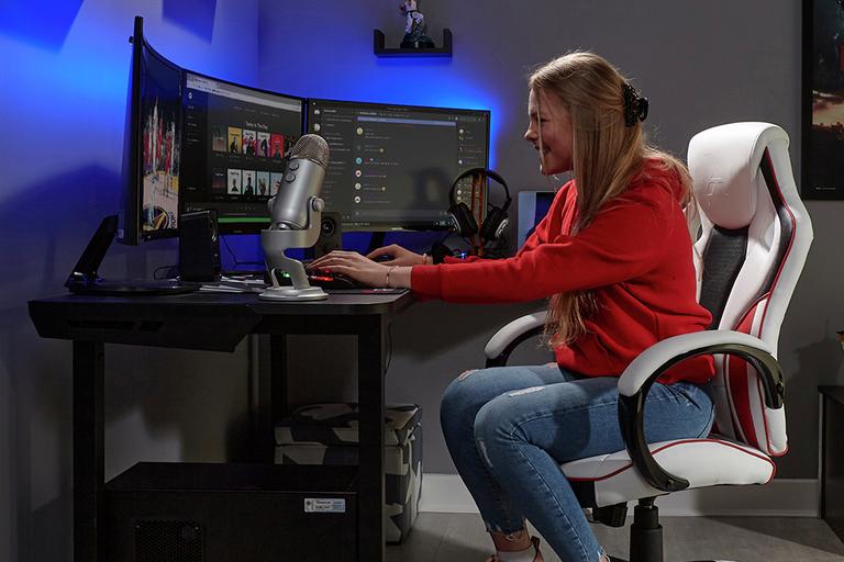 A woman plays with a gaming PC.