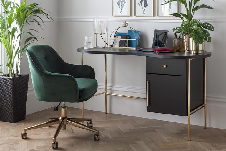 A compact home office set up with a storage desk and a velvet office chair. 