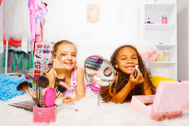 Two young girls playing with makeup.