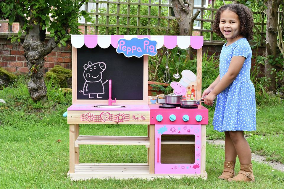 Image of a girl playing with a Peppa Pig mud kitchen.