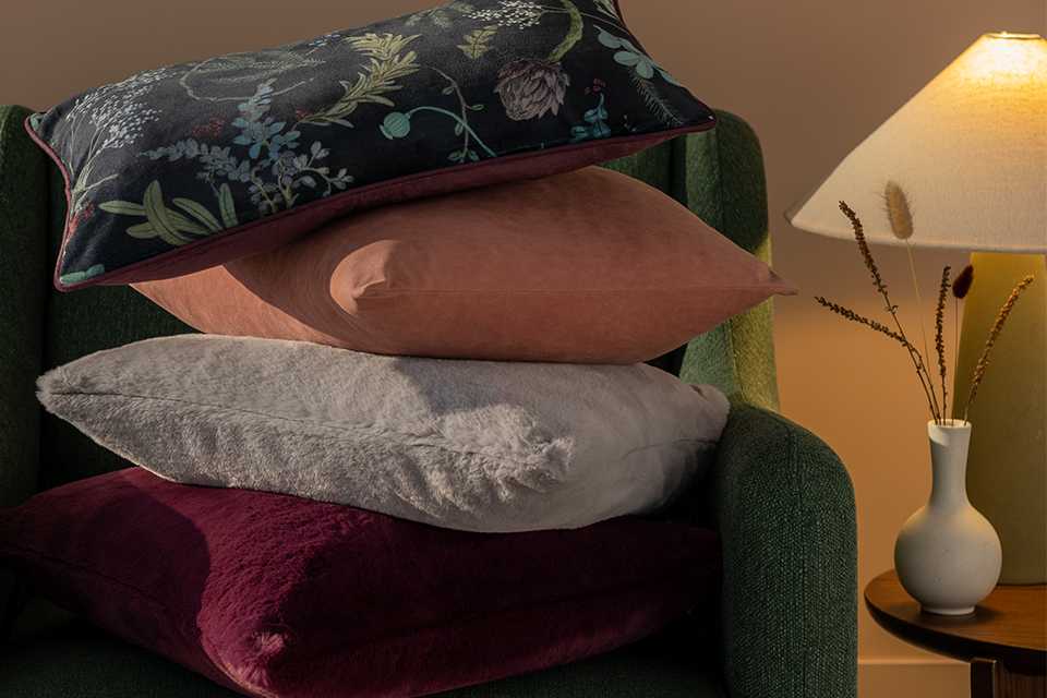 A selection of 4 cushions stacked with faux fur textures and prints.