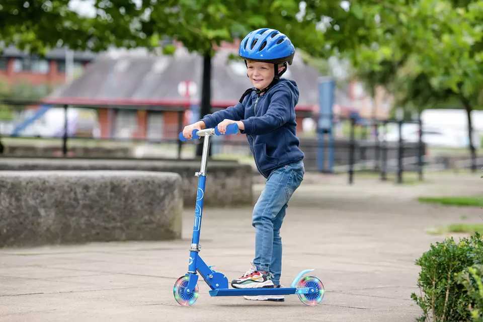 A boy on a 2-wheel scooter.