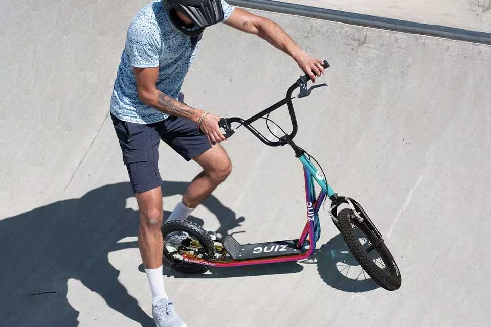 A boy riding a big wheel scooter.