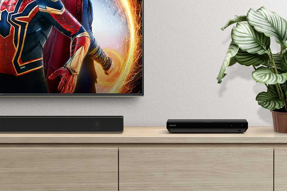 A Blu-ray player sitting on a TV unit.