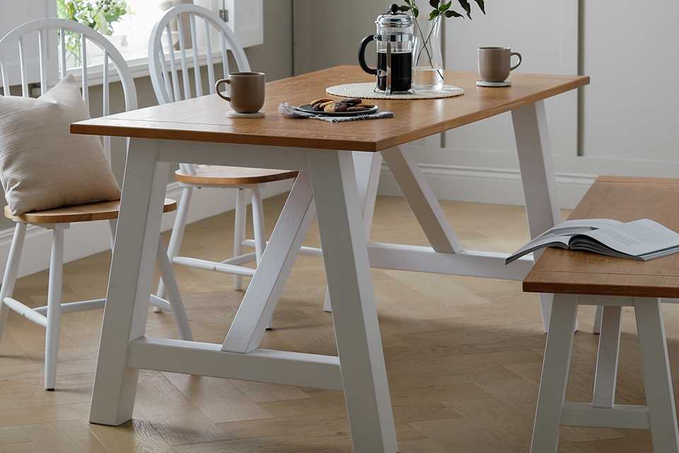 Wooden dining table with grey wooden legs and bench.