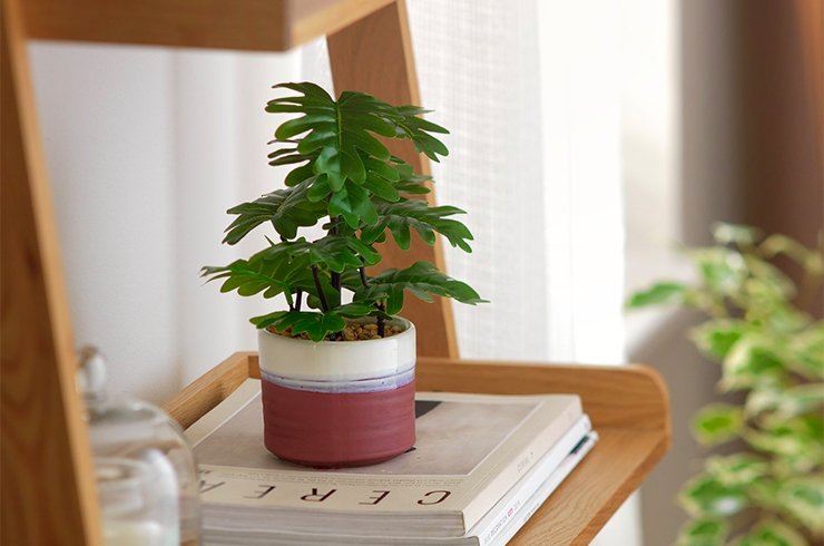 Faux floral plant in a terracotta ceramic pot.