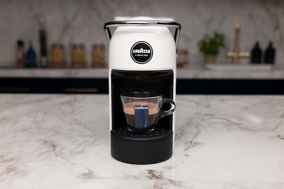 The Lavazza A Modo Mio Jolie coffee machine pouring a cup of espresso.