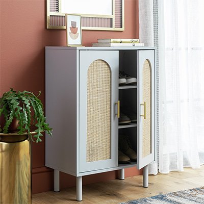 Light blue wooden cabinet with wooden arched rattan doors inpeach coloured hallway.