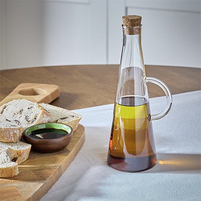 Kitchen counter with oil bottle and bread board.