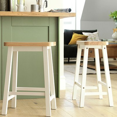 White wooden kitchen bar stooks next to sage green counter for space saving in your kitchen.
