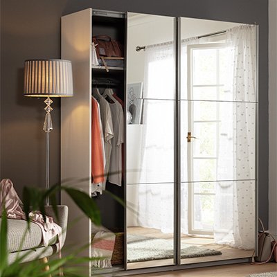 Mirrored wardrobe with sliding doors in bedroom.