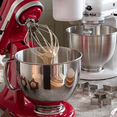 Baking whisk machine in red in kitchen on to of counter.