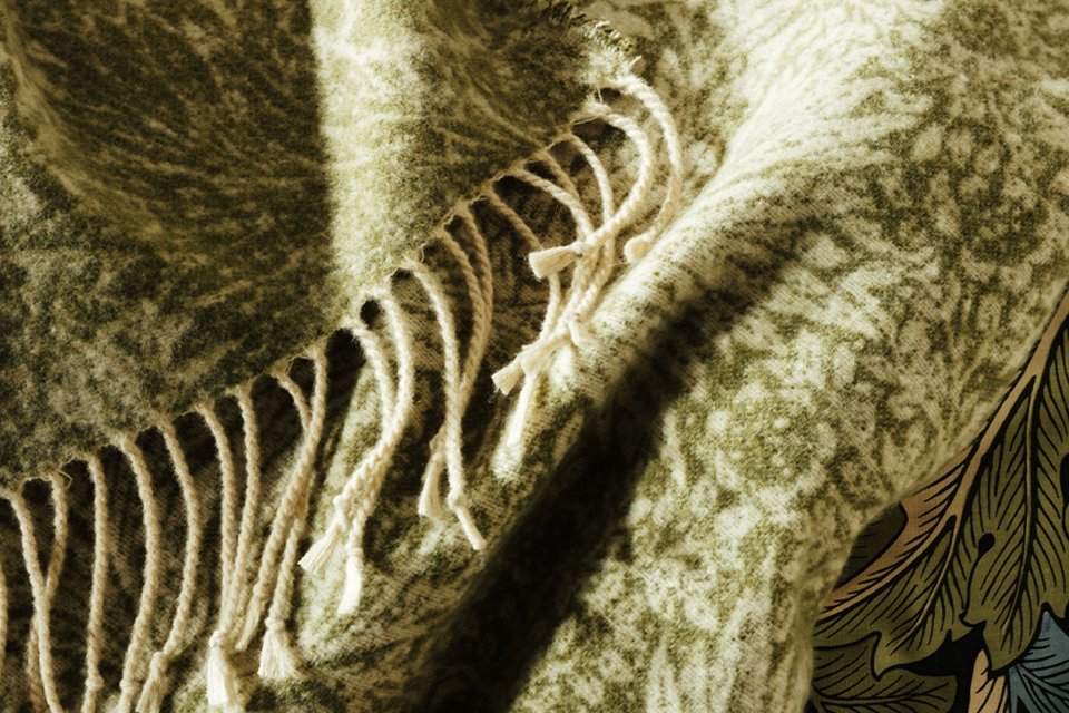 Habitat x Morris & Co collaboration green floral patterned throw with Morris & Co logo.