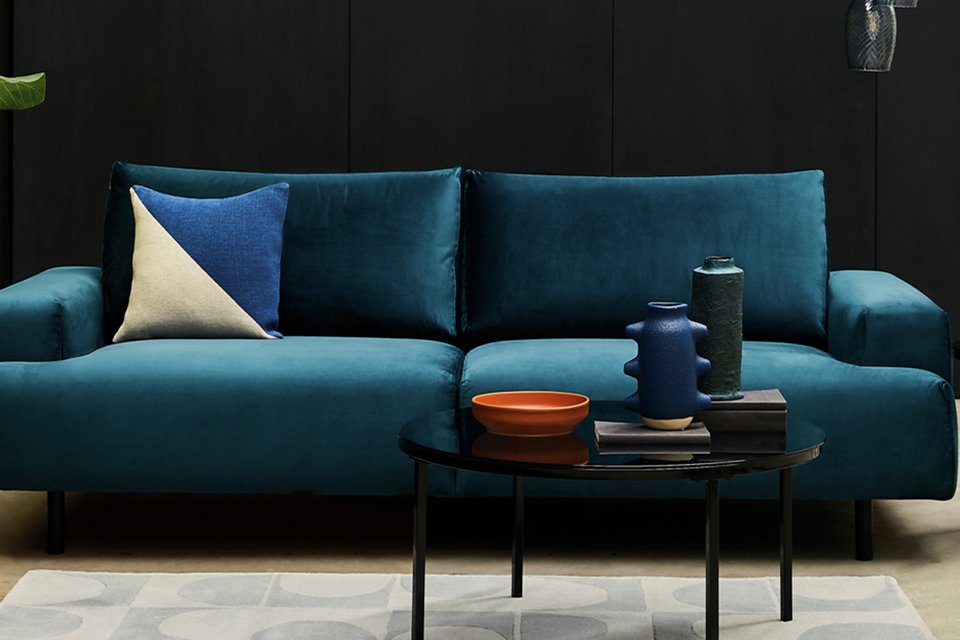 Blue velbvet two seater sofa in living room.