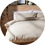 Cream bedding on wooden bed.