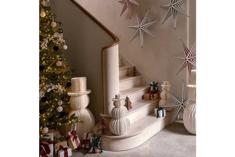 Image of a set of stairs surrounded by paper Christmas decorations with a white colour scheme