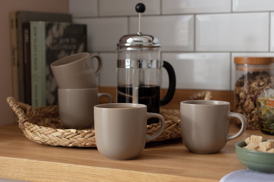 Matt grey coffee mugs on a counter top.