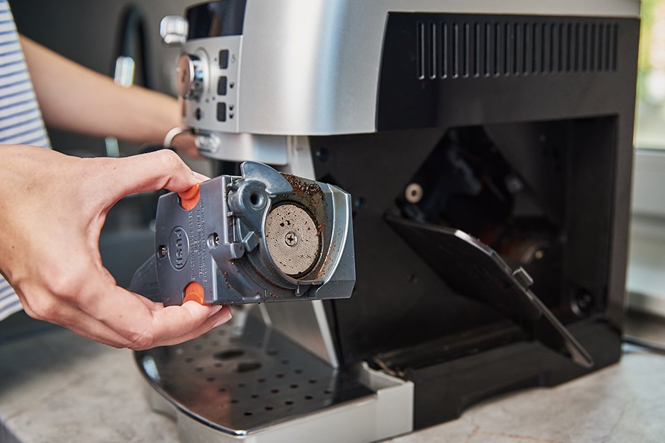A person cleaning the coffee machine.