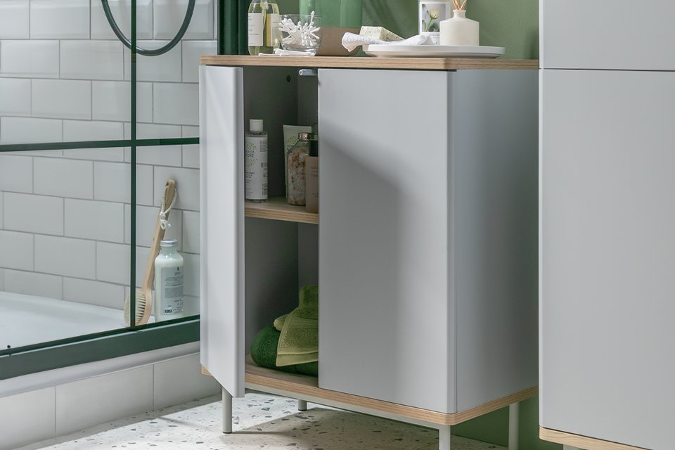 Bathroom storage unit in green bathroom.