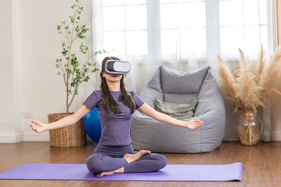 A woman using VR headset to do yoga.