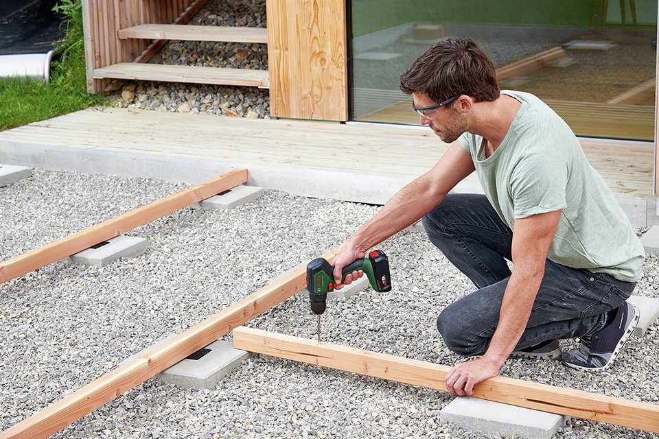 Man drilling plank of wood.