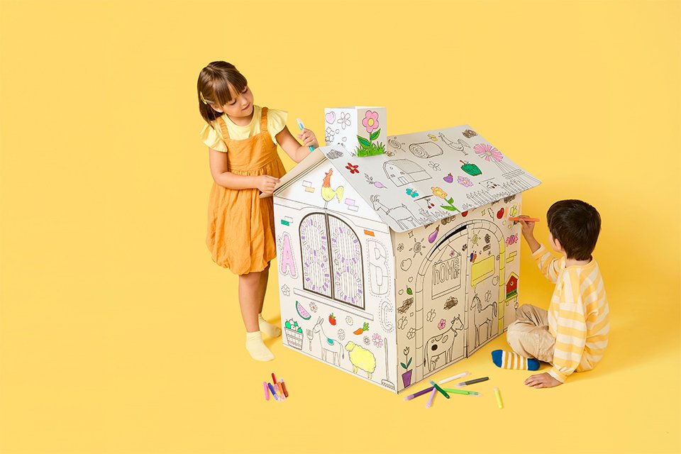 Two toddlers building a mini fort using Chad Valley's creative toys.