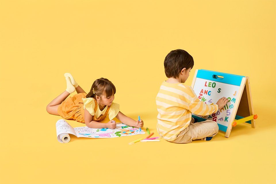 Two toddlers drawing using Chad Valley's art toys.