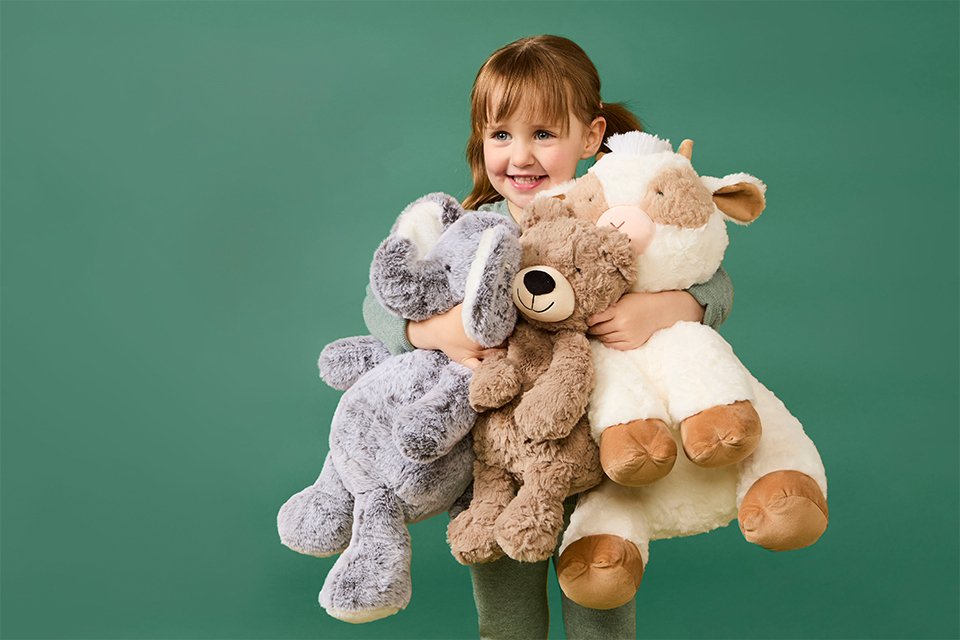 A girl hugging two Chad Valley plush toys.