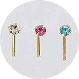Three gold nose pins with colourful stones.