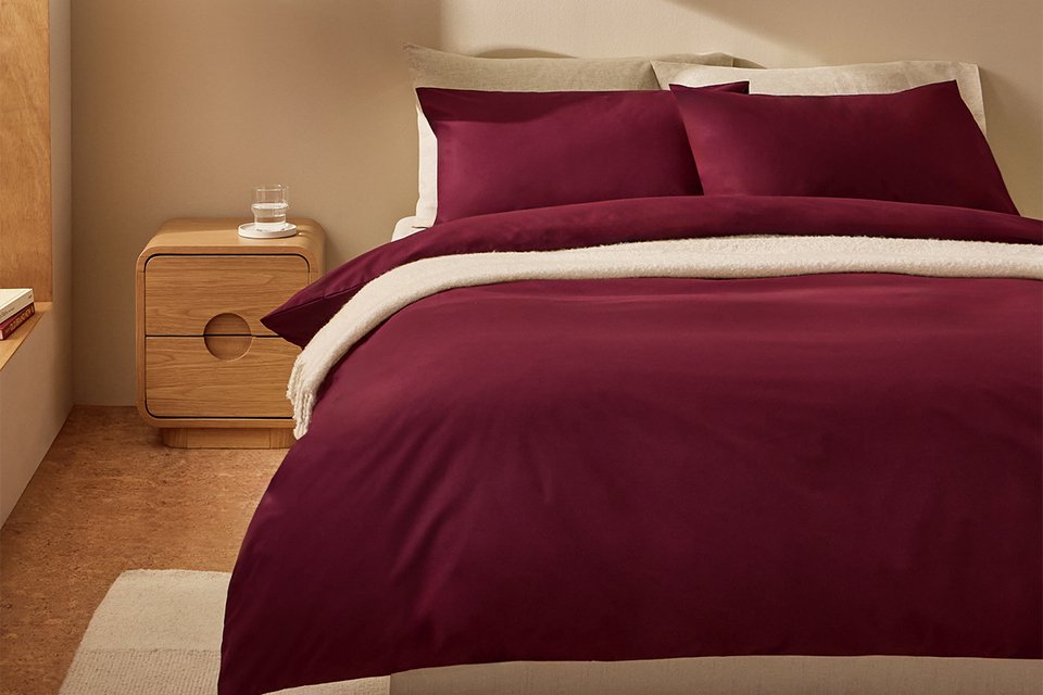 A bed made with a burgundy Habitat cotton king size bedding set.