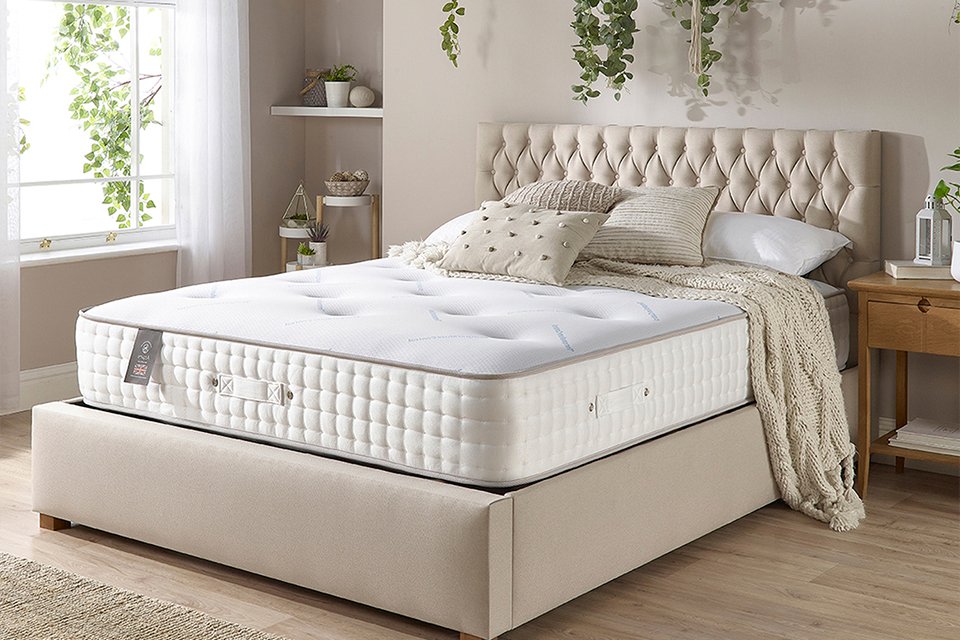An Aspire dual side pocket spring mattress on a bed.