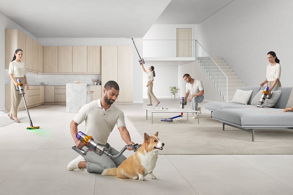 A man and woman showing different functionalities of the Dyson vacuum tools and accessories.
