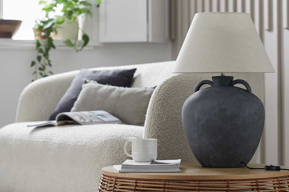Oversized ceramic table lamp with cream lamp shade.