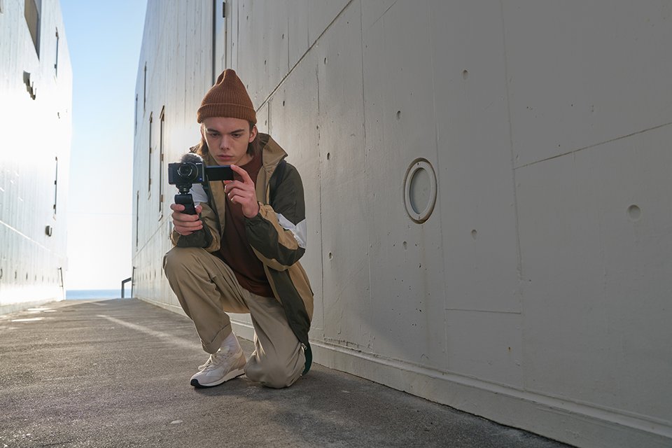 A man holding a Sony vlogging camera.