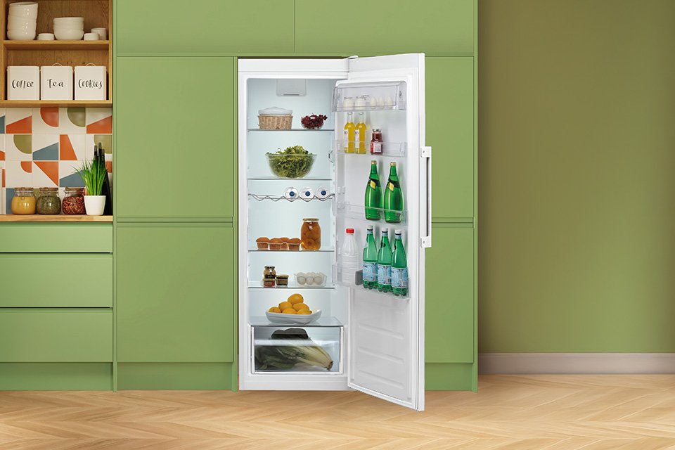 A Hotpoint white fridge seamlessly built into modern green kitchen cabinets.
